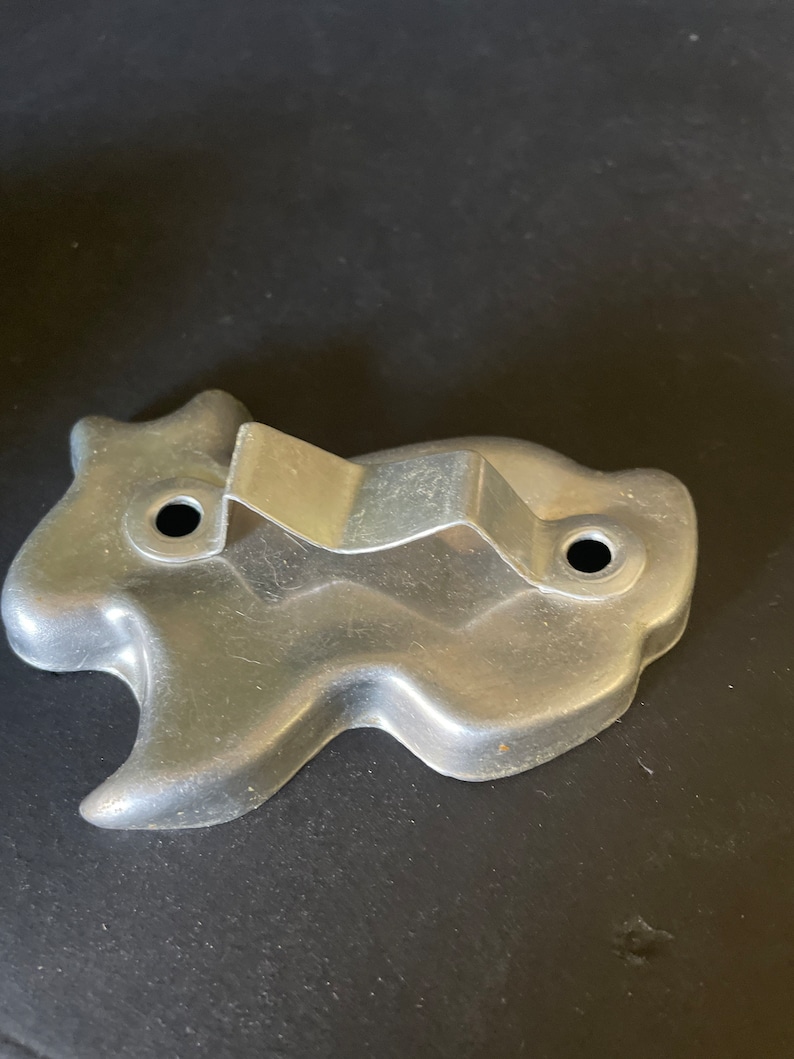 May include: A silver metal cookie cutter shaped like a ghost. The cutter has a handle on the back.