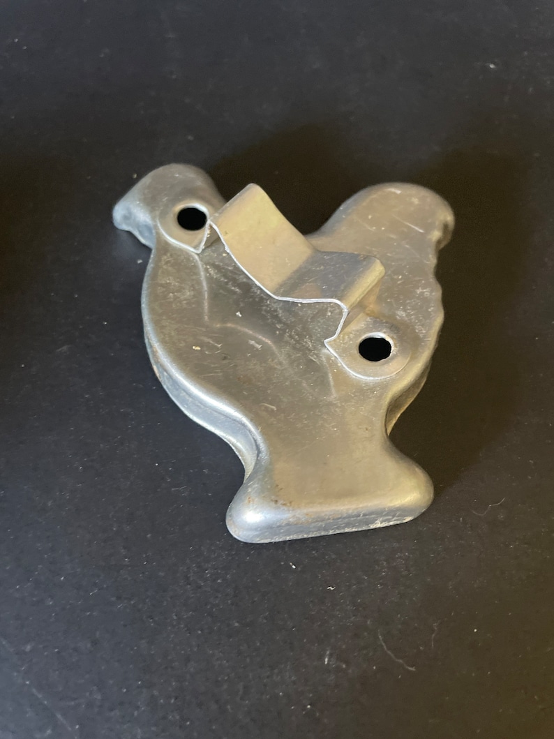 May include: A vintage metal cookie cutter shaped like a turkey. The cutter has two holes on the side and a metal handle.