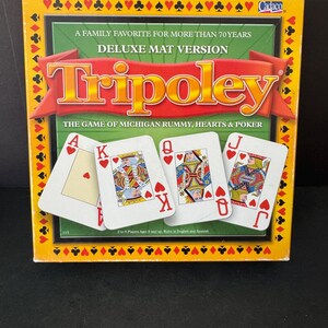 May include: Tripoley Deluxe Mat Version board game box. The box is yellow with a green center and features the game title in large red letters. Four playing cards are displayed, with the Ace of Hearts, King, Queen, and Jack of Hearts visible.
