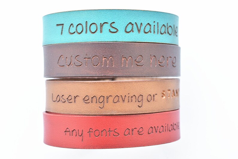 Pu&ograve; includere: Pila di quattro braccialetti in pelle di diversi colori, ognuno con un messaggio inciso diverso. Il braccialetto superiore &egrave; turchese e dice "7 colori disponibili". Il secondo braccialetto &egrave; marrone e dice "Personalizzami qui". Il terzo braccialetto &egrave; color sabbia e dice "Incisione laser o timbro". Il braccialetto inferiore &egrave; rosso e dice "Tutti i font sono disponibili".