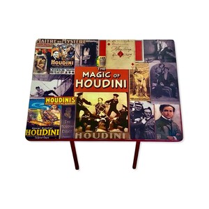 May include: A red table with a collage of vintage images of Harry Houdini. The table top features images of Houdini performing various magic tricks, including escaping from a straitjacket and being tied up with ropes. The table top also features text that reads "The Magic of Houdini".