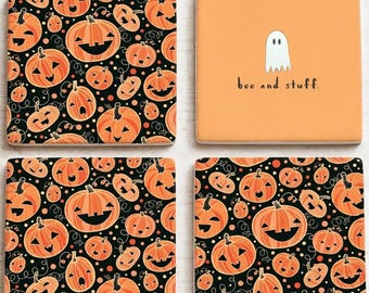 May include: Four square coasters featuring Halloween designs. Three coasters display a black background with a repeating pattern of orange jack-o'-lanterns. One coaster has a solid orange background with a white ghost and the text boo and stuff.