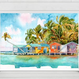 May include: Watercolor painting of colorful beach huts on stilts, set against a backdrop of palm trees and a bright blue sky. The huts are painted in shades of blue, yellow, orange, and purple. The artwork is framed in white.