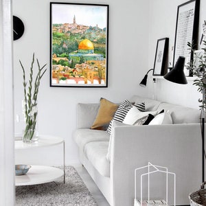 Peut inclure: Une peinture &agrave; l'aquarelle du D&ocirc;me du Rocher &agrave; J&eacute;rusalem, encadr&eacute;e et accroch&eacute;e &agrave; un mur blanc dans un salon. La peinture est au-dessus d'un canap&eacute; blanc avec des coussins et une table basse blanche.