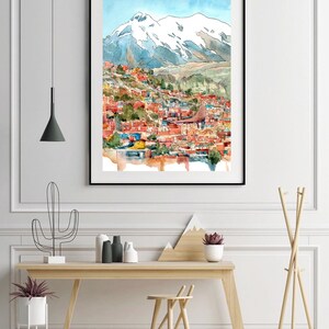 Pu&ograve; includere: Un dipinto ad acquerello di una citt&agrave; incastonata in una valle di montagna. La citt&agrave; &egrave; dipinta in tonalit&agrave; di rosso, arancione e giallo, con una montagna innevata sullo sfondo. Il cielo &egrave; azzurro chiaro con nuvole bianche.