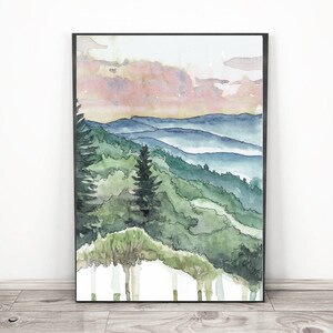 May include: Watercolor painting of a mountain landscape with a pink and purple sky. The mountains are covered in green trees and there is a layer of fog in the valleys.