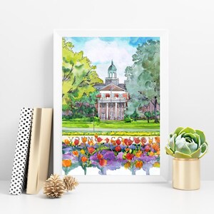 K&ouml;nnte beinhalten: Aquarellgem&auml;lde eines Backsteingeb&auml;udes mit gr&uuml;nem Dach und einer wei&szlig;en S&auml;ulenfassade. Das Geb&auml;ude ist von gr&uuml;nen B&auml;umen und einem Beet mit bunten Blumen umgeben.