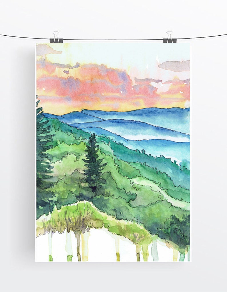 May include: Watercolor painting of a mountain landscape with a sunset sky. The painting features a series of blue mountains with a green forest in the foreground. The sky is a mix of pink, orange, and yellow.