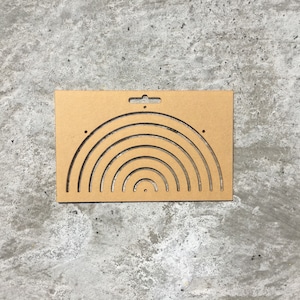 May include: A brown cardboard cutout of a rainbow with seven arches. The cutout has a hole at the top for hanging.