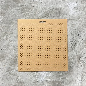 Può includere: Un pannello perforato marrone con una griglia di fori equidistanti. Il pannello perforato ha un piccolo foro nella parte superiore per appenderlo.