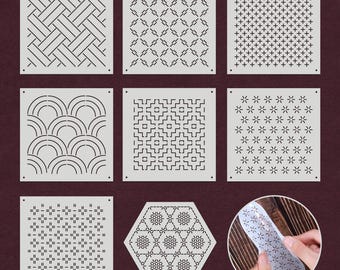 May include: Set of nine white square stencils with different geometric patterns. The patterns include a woven design, a diamond pattern, a plus sign pattern, a wave pattern, a square pattern, a flower pattern, a small square pattern, a hexagonal pattern, and a larger hexagonal pattern.