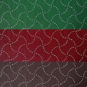 May include: A close-up of three fabric swatches with a repeating pattern of white dashed lines forming circles. The top swatch is green, the middle swatch is red, and the bottom swatch is brown.