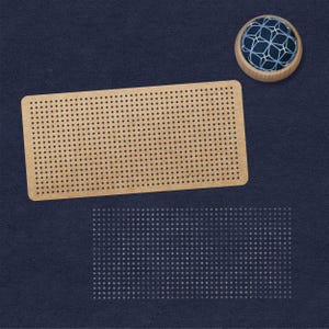 May include: A brown pegboard with a grid of evenly spaced holes. A blue and white pincushion sits on a dark blue surface.