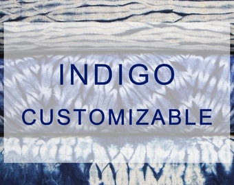Op de afbeelding: Indigo-stof met een tie-dye-patroon in tinten blauw en wit. De stof is aanpasbaar.