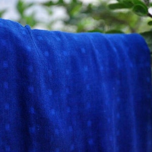 May include: A close-up of a blue fabric with a white pattern. The fabric has a soft, textured feel and is perfect for crafting or sewing projects.