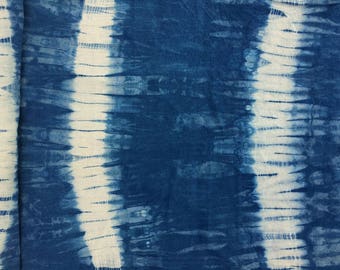 Peut inclure: Un tissu bleu et blanc en tie-dye avec un motif vertical. Le tissu a une surface texturée et irrégulière.