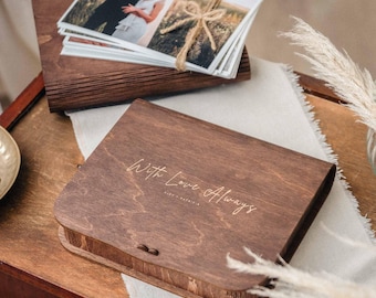 May include: A dark brown wooden box with a hinged lid. The box has a curved edge and is engraved with the text "With Love Always".