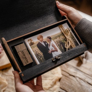 May include: A wooden box with a hinged lid, containing a printed photograph of a couple in a field and a USB drive labeled "Memories".