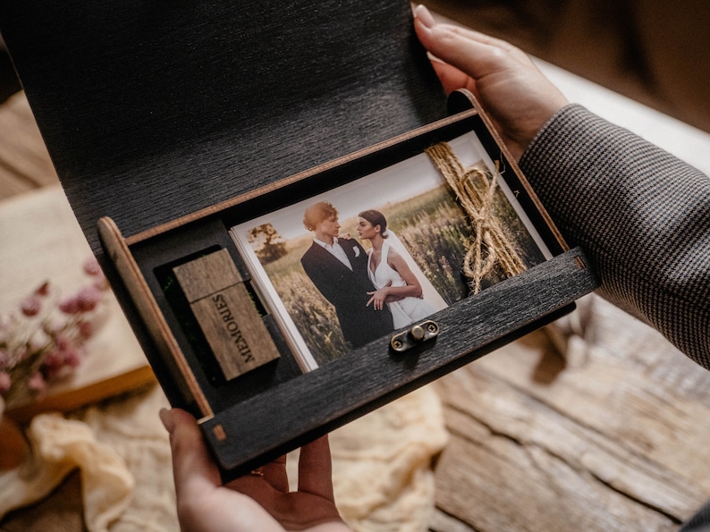 May include: A wooden box with a hinged lid, containing a printed photograph of a couple in a field and a USB drive labeled "Memories".