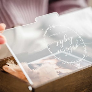 Close-up of engraved clear acrylic lid on walnut photo box, personalized name/date example.
