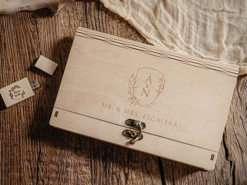 May include: A wooden box with a hinged lid and a metal latch. The box is engraved with the initials "A & N" and the text "MR. & MRS. ESCALERA".