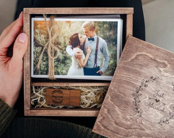 Könnte beinhalten: Eine Holzkiste mit einem Foto eines Paares darin. Die Kiste ist mit den Worten "Just Married" graviert und hat einen kleinen Holz-USB-Stick mit der Gravur "Photos & Files".