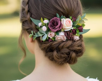 May include: A hair comb featuring an arrangement of artificial flowers including deep burgundy roses, soft blush pink roses, small light pink blossoms, dark red berries, and various green eucalyptus leaves tucked into a braided hairstyle.
