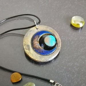 Ciondolo in ceramica Raku con tripla luna, simbolo wiccan minimalista, collana artigianale regolabile.
Raku ceramic pendant with triple moon, minimalist Wiccan symbol, adjustable handcrafted necklace.