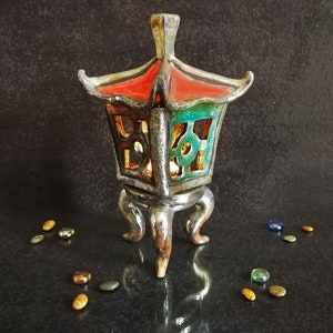 Lanterna per tealight Oki Gata in ceramica raku turchese con tetto rosso e treppiede dorato, colori personalizzabili.
Oki Gata Tealight Lantern in Turquoise Raku Ceramic with Red Roof and Golden Tripod, Customizable Colors.