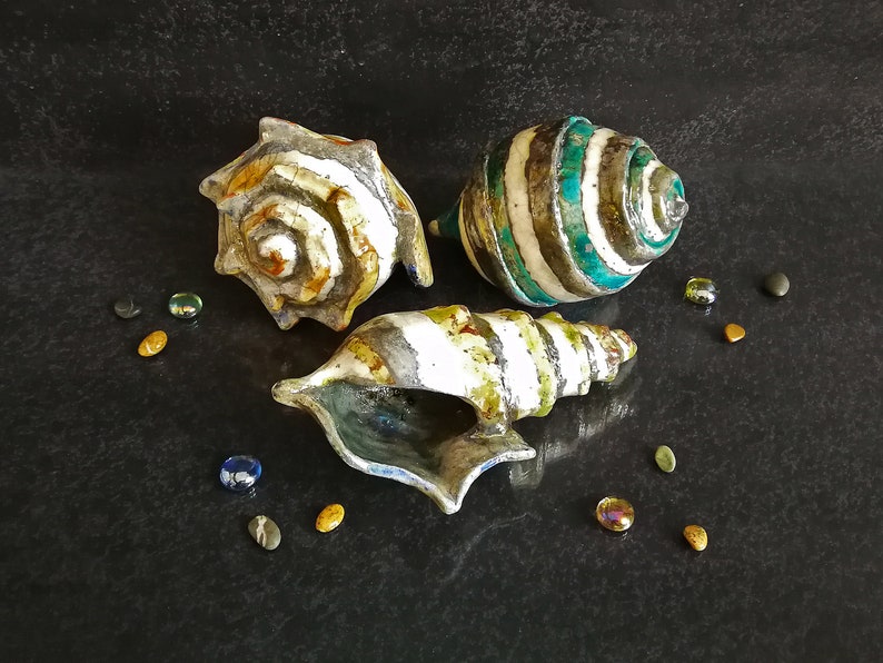Set di conchiglie in ceramica Raku con smalto craquelé. Aggiungono un tocco costiero ed elegante alla tua casa.
Set of Raku ceramic shells with crackled glaze. Add a coastal and elegant touch to your home.