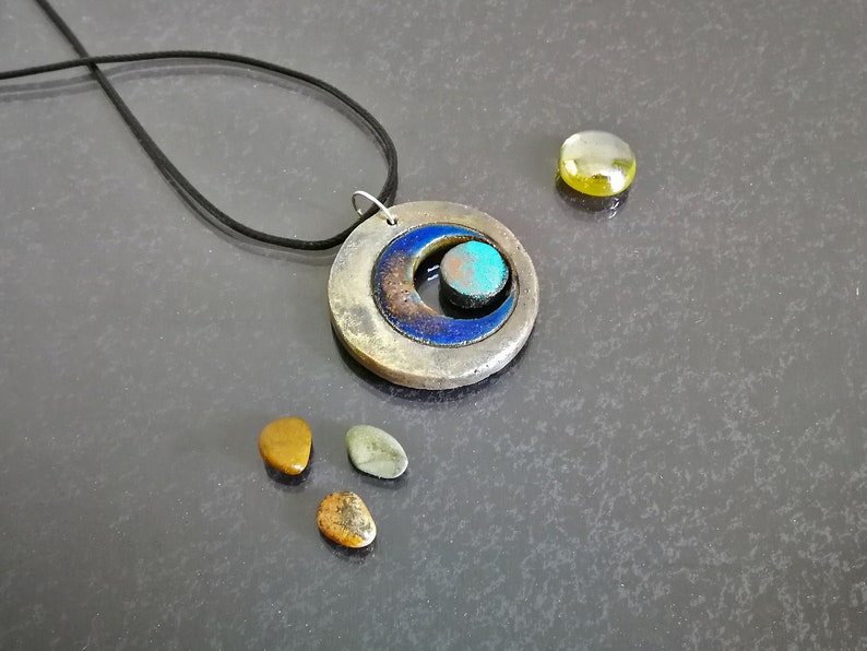Gioiello ispirato alla dea triplice in ceramica Raku, stile moderno, ideale per look spirituali ed eleganti.
Jewelry inspired by the Triple Goddess in Raku ceramic, modern style, perfect for spiritual and elegant looks.