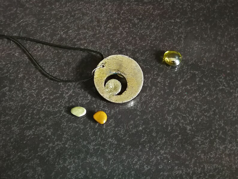 Ciondolo con fasi lunari in ceramica Raku, stile boho minimalista, decorato con colori iridescenti.
Raku ceramic moon phase pendant, minimalist boho style, decorated with iridescent colors.