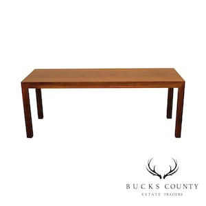 May include: A long, rectangular wooden coffee table with a dark brown finish and simple, square legs.