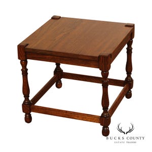 May include: A square, wooden side table with a dark brown finish. The table has a flat top with decorative corner accents and turned legs. The legs are connected by a lower frame, and the table is approximately 20 inches wide and 20 inches deep.