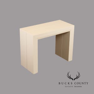 May include: A cream-colored rectangular console table with a U-shaped base. The table is made of solid material and has a simple, modern design. The table is approximately 30 inches tall, 48 inches wide, and 16 inches deep.