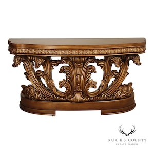 May include: A half-moon shaped, antique-style console table. The table features a warm, golden-brown finish with intricate, carved floral and scrollwork details. The table's design includes a curved top and a decorative base.