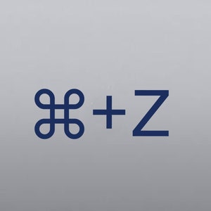May include: A silver laptop computer with a blue sticker that says "⌘ + Z" on the back.