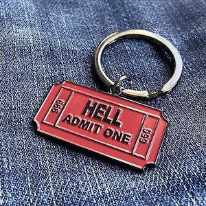 May include: Red metal keychain shaped like a ticket with the text "HELL ADMIT ONE" and the number 666 on each side.