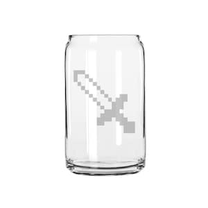 May include: A clear glass can with a gray pixelated sword design. The can is shaped like a traditional soda can.