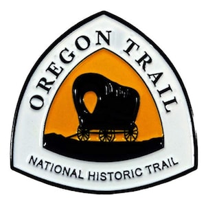 May include: A white triangular patch with a black border and the words "Oregon Trail National Historic Trail". Inside the triangle is a yellow background with a black silhouette of a covered wagon.