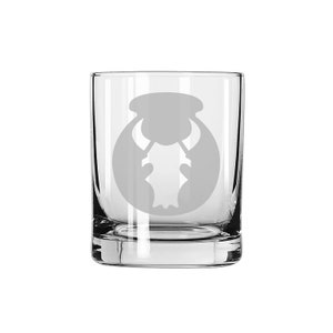 May include: A clear glass tumbler with a white etched design of a bull's head inside a circle.
