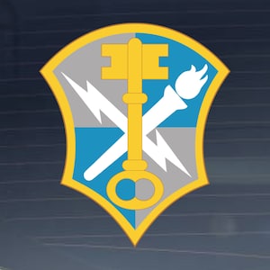 May include: A yellow shield with a key, a torch, and lightning bolts. The shield is divided into four sections, with a blue section in the upper right, a gray section in the upper left, a gray section in the lower right, and a blue section in the lower left.