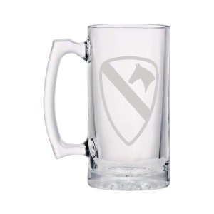 Könnte beinhalten: Ein klares Glasbierkrug mit Henkel. Der Krug hat ein geätztes Design eines Pferdekopfes in einem Schild mit einem diagonalen Streifen.