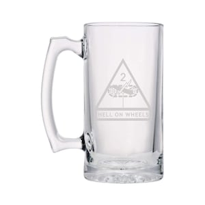 May include: A clear glass beer stein with a handle. The stein is etched with the 2nd Armored Division insignia, a triangle with a lightning bolt and a cannon, and the words "Hell on Wheels".