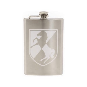 May include: A silver stainless steel flask with a white engraved image of a horse on a shield.