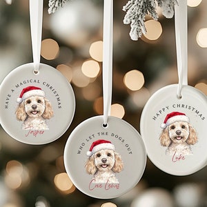 May include: Three round Christmas ornaments with watercolor portraits of dogs wearing Santa hats. Each ornament has a white ribbon for hanging and features a different message: "Have a Magical Christmas," "Who Let the Dogs Out," and "Happy Christmas."