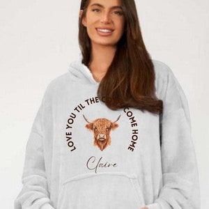 May include: A white hooded sweatshirt with a brown Highland cow illustration and the text "Love you til the cows come home" and the name "Claire" printed on the front.