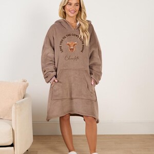 May include: A brown fleece oversized hoodie with a kangaroo pocket and a cow graphic. The graphic says "Love you til the cows come home" and has the name "Charlotte" underneath.
