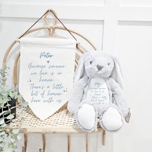 May include: A gray plush bunny with long ears and a white belly. The bunny is embroidered with the text "Peter Because someone we love is in heaven There's a little bit of heaven here with us".