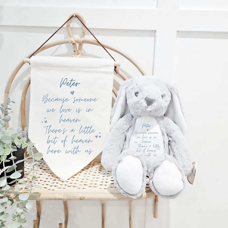 May include: A gray plush bunny with long ears and a white belly. The bunny is embroidered with the text "Peter Because someone we love is in heaven There's a little bit of heaven here with us".